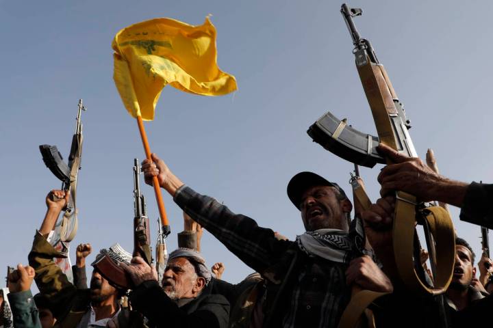 Houthi supporters raise a Hezbollah flag during an anti-Israel and anti-U.S. rally in Sanaa, Ye ...