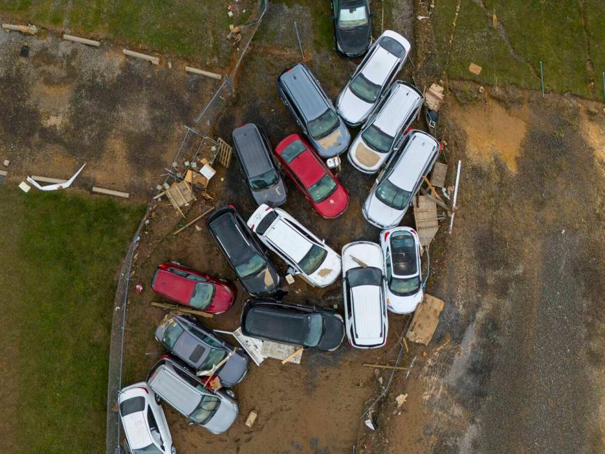 Vehicles and debris that were caught in a flash flood from Hurricane Helene rest on the side of ...