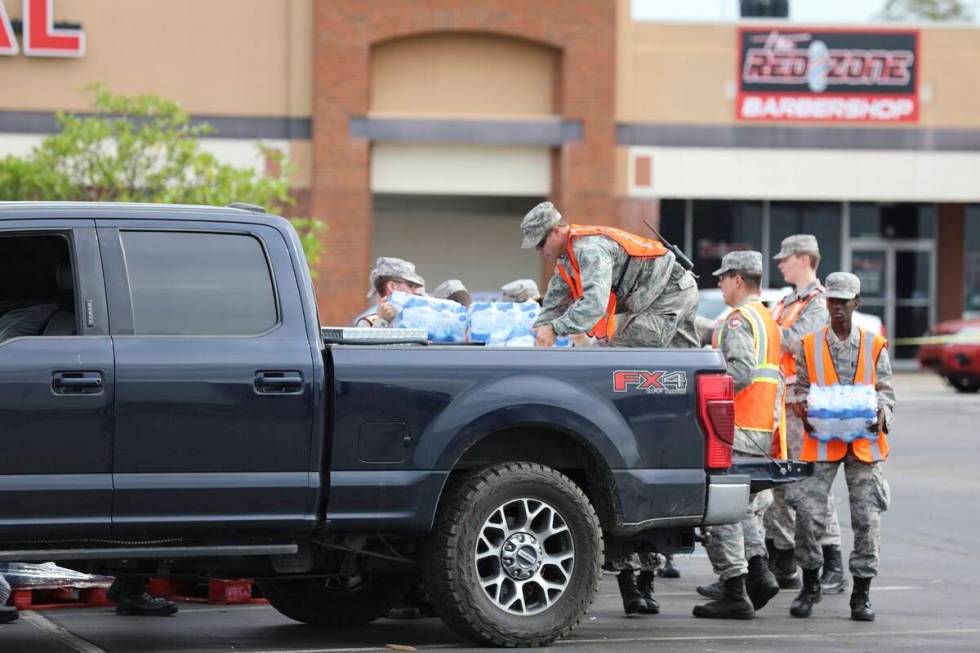 Members of the Civil Air Patrol load water for Hurricane Helene relief into a pickup truck at a ...