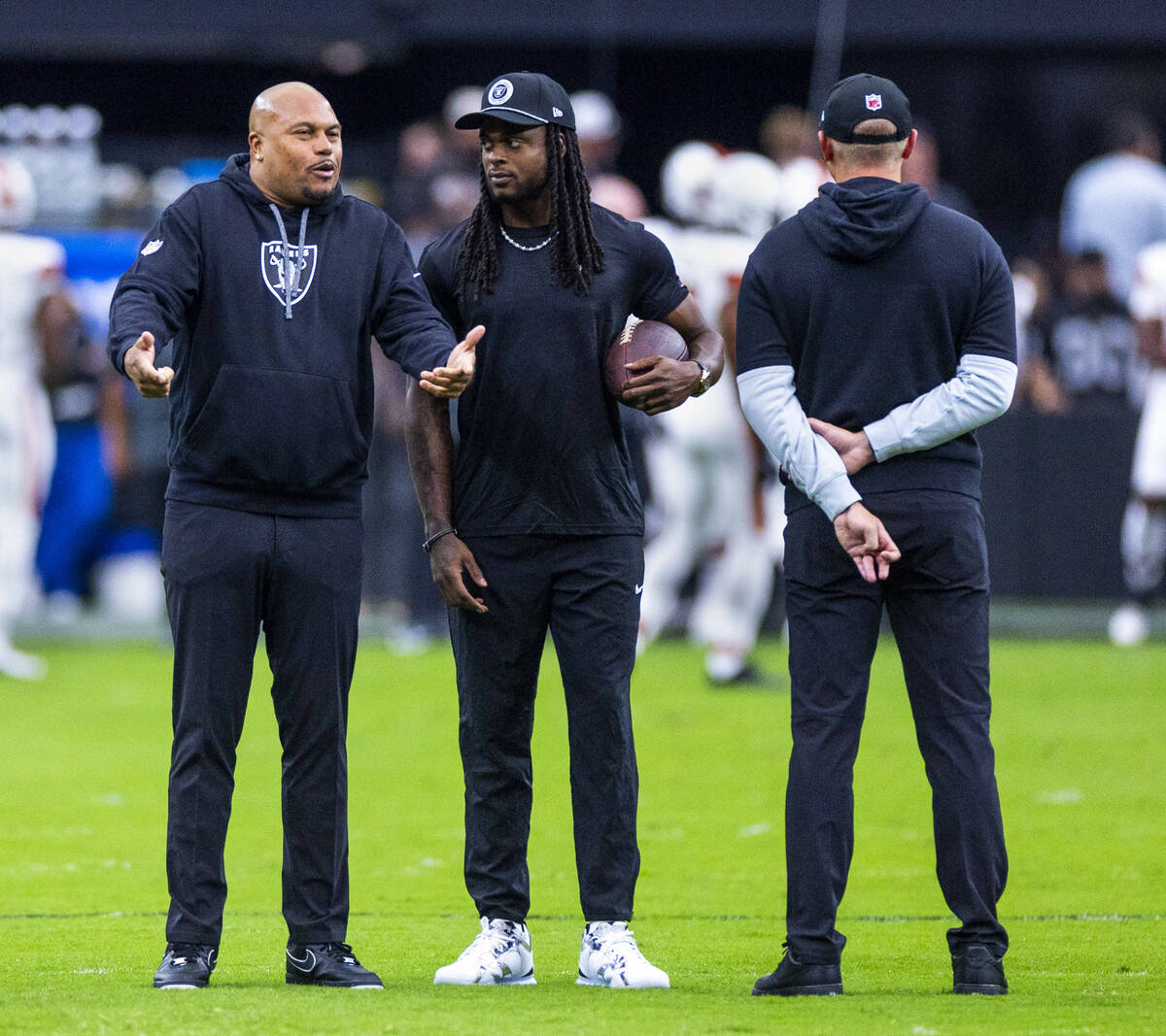 Raiders Head Coach Antonio Pierce chats with wide receiver Davante Adams (17) during the warm u ...