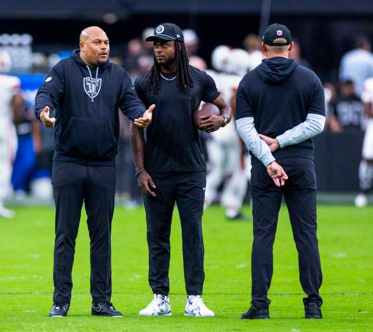 Raiders Head Coach Antonio Pierce chats with wide receiver Davante Adams (17) during the warm u ...