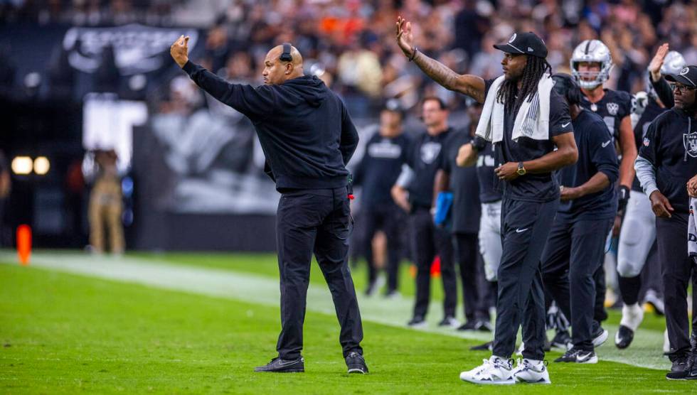 Raiders Head Coach Antonio Pierce and wide receiver Davante Adams (17) signal players on the fi ...