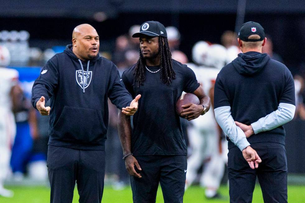 Raiders Head Coach Antonio Pierce chats with wide receiver Davante Adams (17) during the warm u ...