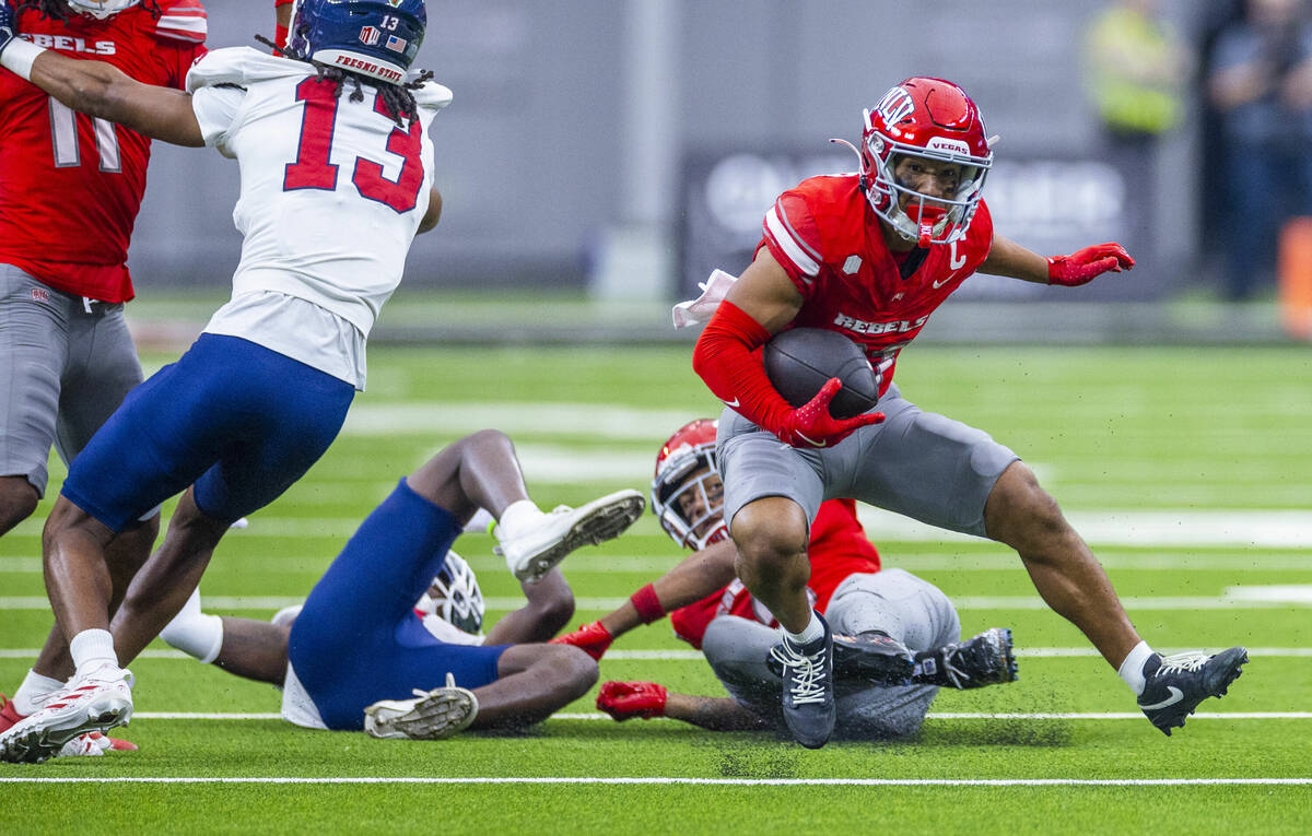 UNLV wide receiver Jacob De Jesus (21) runs back a punt and cuts up field past Fresno State Bul ...