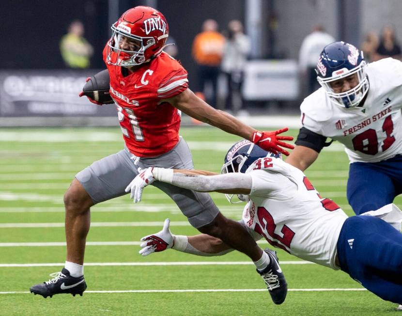 UNLV wide receiver Jacob De Jesus (21) avoids Fresno State defensive back Dean Clark (32) durin ...