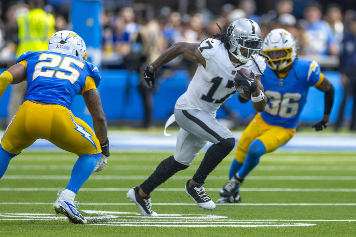 Raiders wide receiver Davante Adams (17) runs for open field past Los Angeles Chargers lineback ...