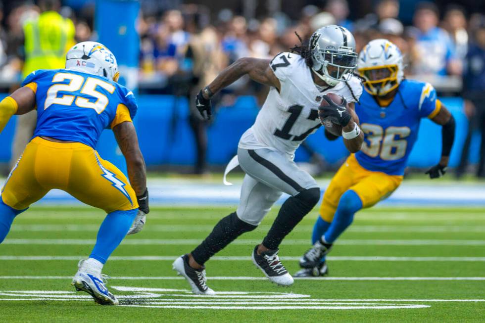 Raiders wide receiver Davante Adams (17) runs for open field past Los Angeles Chargers lineback ...