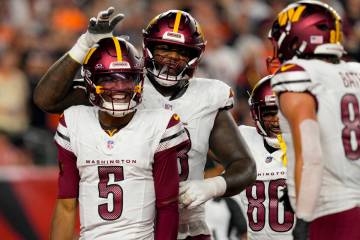 Washington Commanders quarterback Jayden Daniels (5) celebrates with teammates after scoring du ...