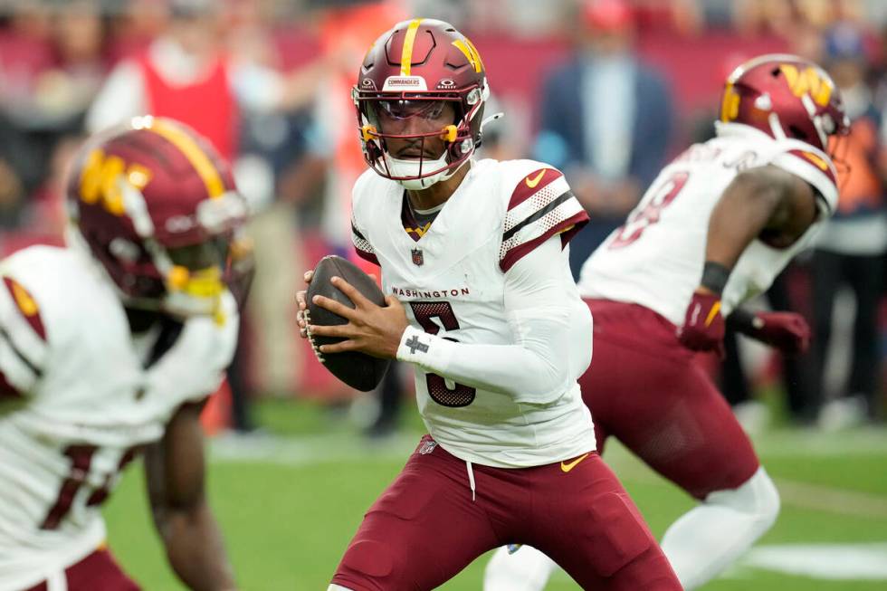 Washington Commanders quarterback Jayden Daniels runs with the ball against the Arizona Cardina ...