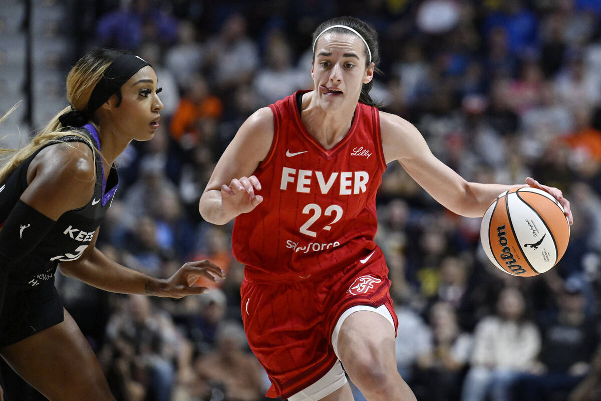 Indiana Fever guard Caitlin Clark (22) drives to the basket as Connecticut Sun guard DiJonai Ca ...