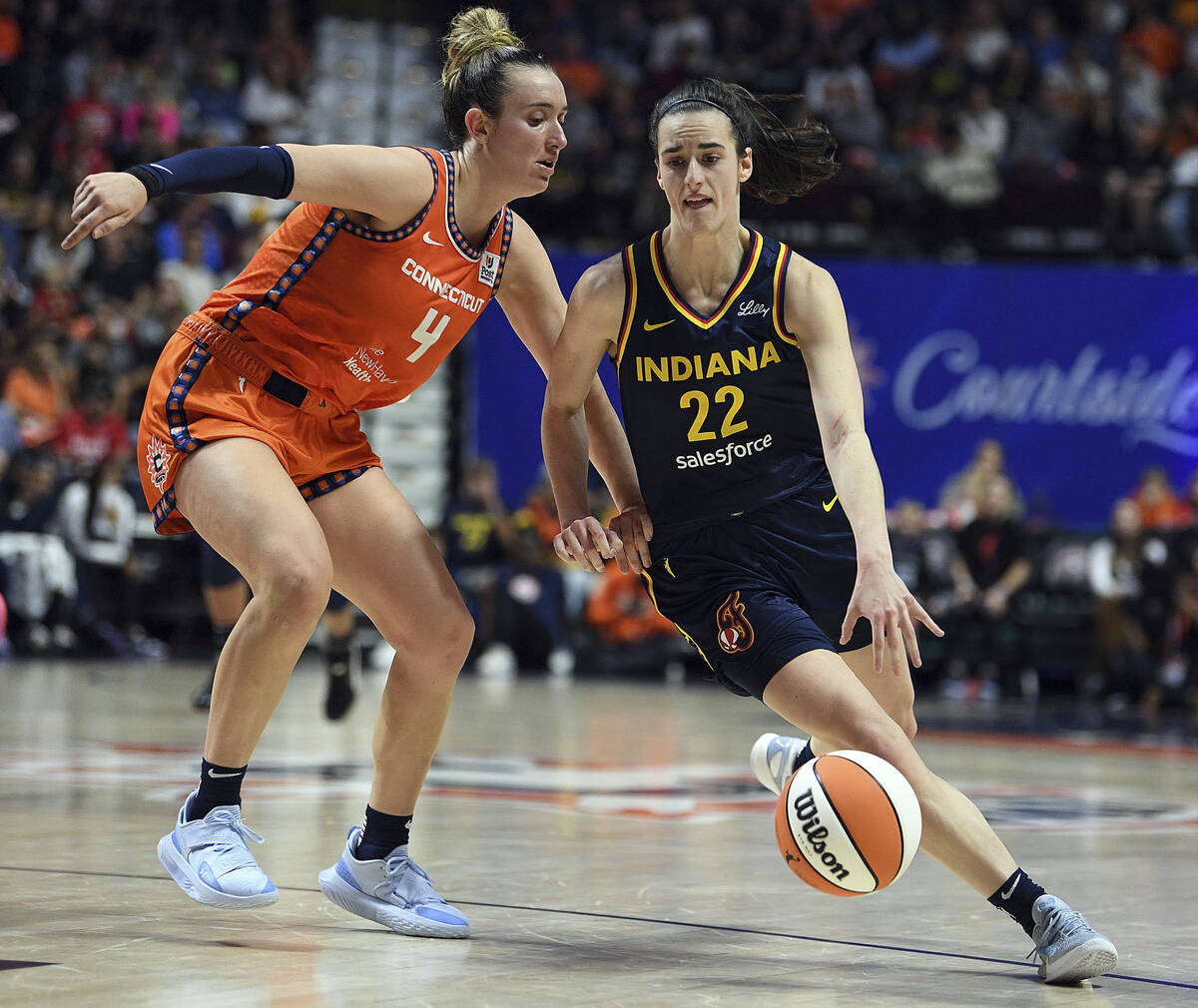 Connecticut Sun's Marina Mabrey (4) guards against Indiana Fever's Caitlin Clark (22) during a ...