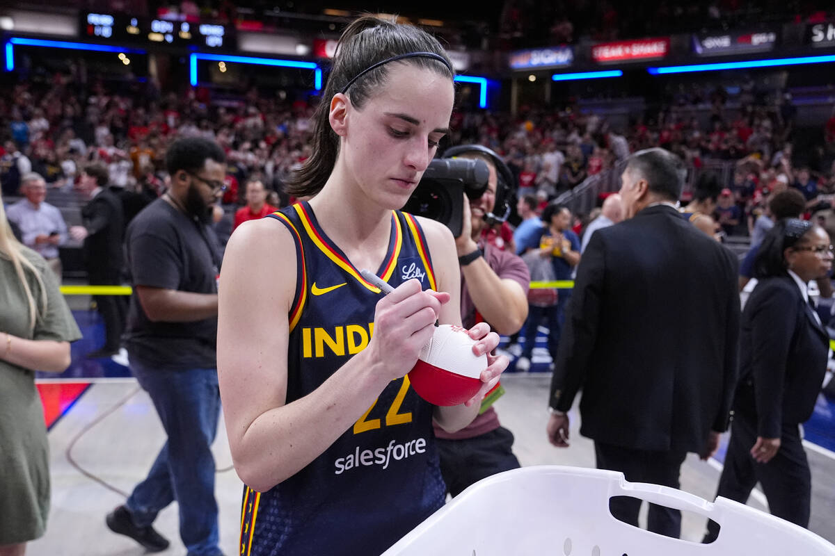 Indiana Fever guard Caitlin Clark (22) signs mini basketballs for fans following in a WNBA bask ...