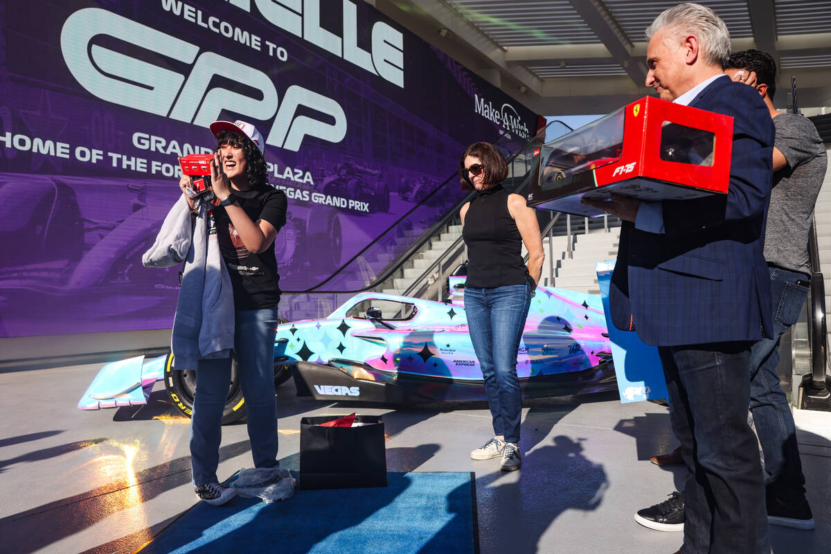 Gabrielle Lowe, 16, opens gifts before taking a behind-the-scenes tour at the F1 Grand Prix Pla ...