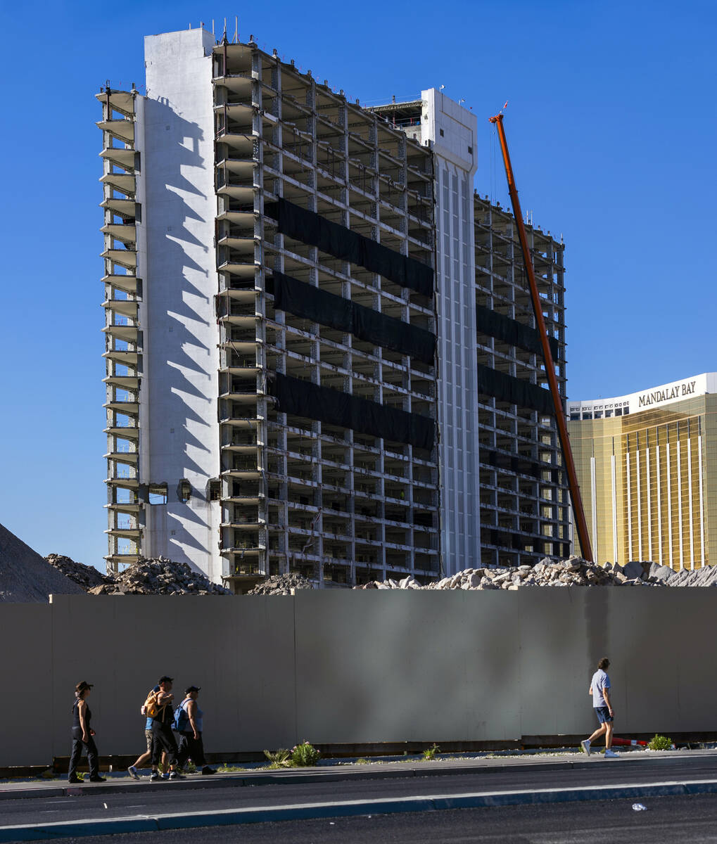 People walk past the temporary wall as preparations for the upcoming implosion continue at the ...