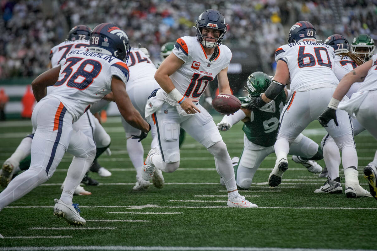 Denver Broncos quarterback Bo Nix (10) hands the ball off to running back Jaleel McLaughlin (38 ...