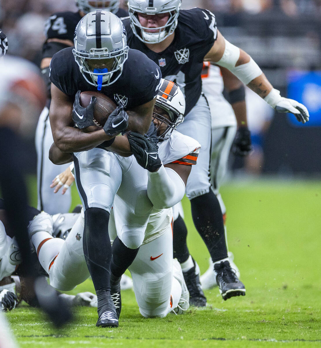 Raiders running back Zamir White (3) drags a Cleveland Browns defender on a run during the firs ...