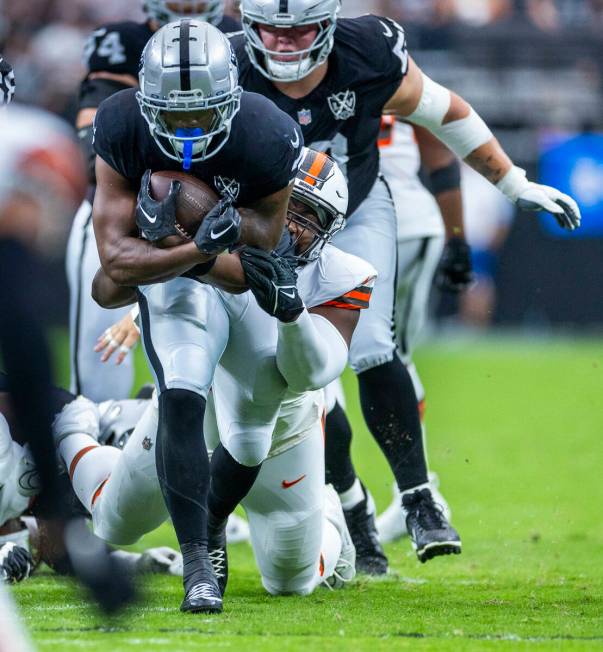 Raiders running back Zamir White (3) drags a Cleveland Browns defender on a run during the firs ...