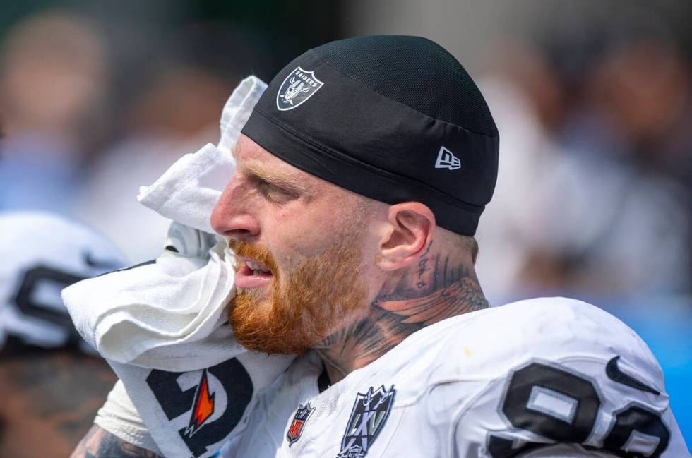 Raiders defensive end Maxx Crosby (98) towels down on the sidelines against the Los Angeles Cha ...