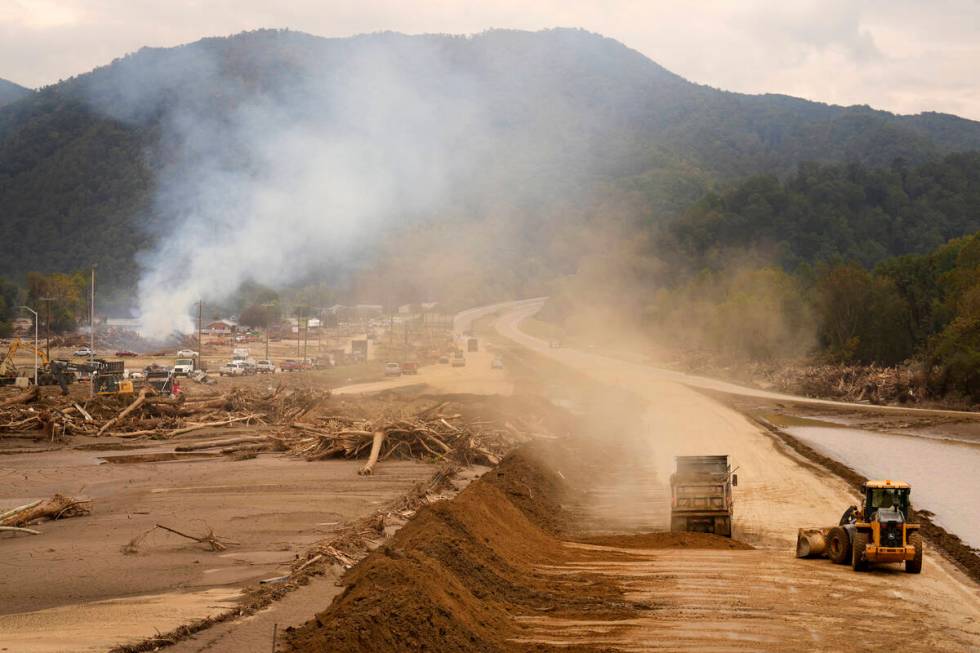 Heavy machinery is used to clear Interstate 26 as debris is burned in the background following ...