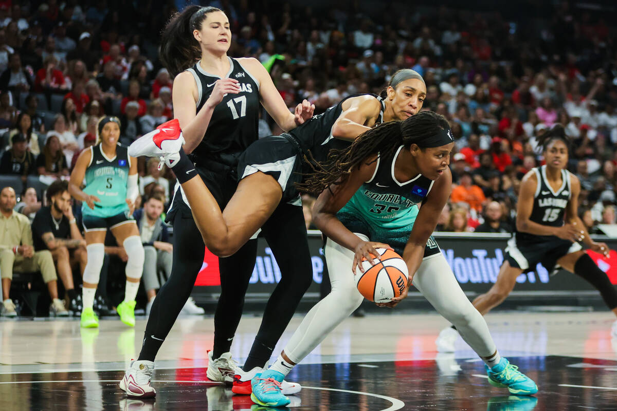 Aces center A'ja Wilson (22) falls over New York Liberty forward Jonquel Jones (35) during game ...