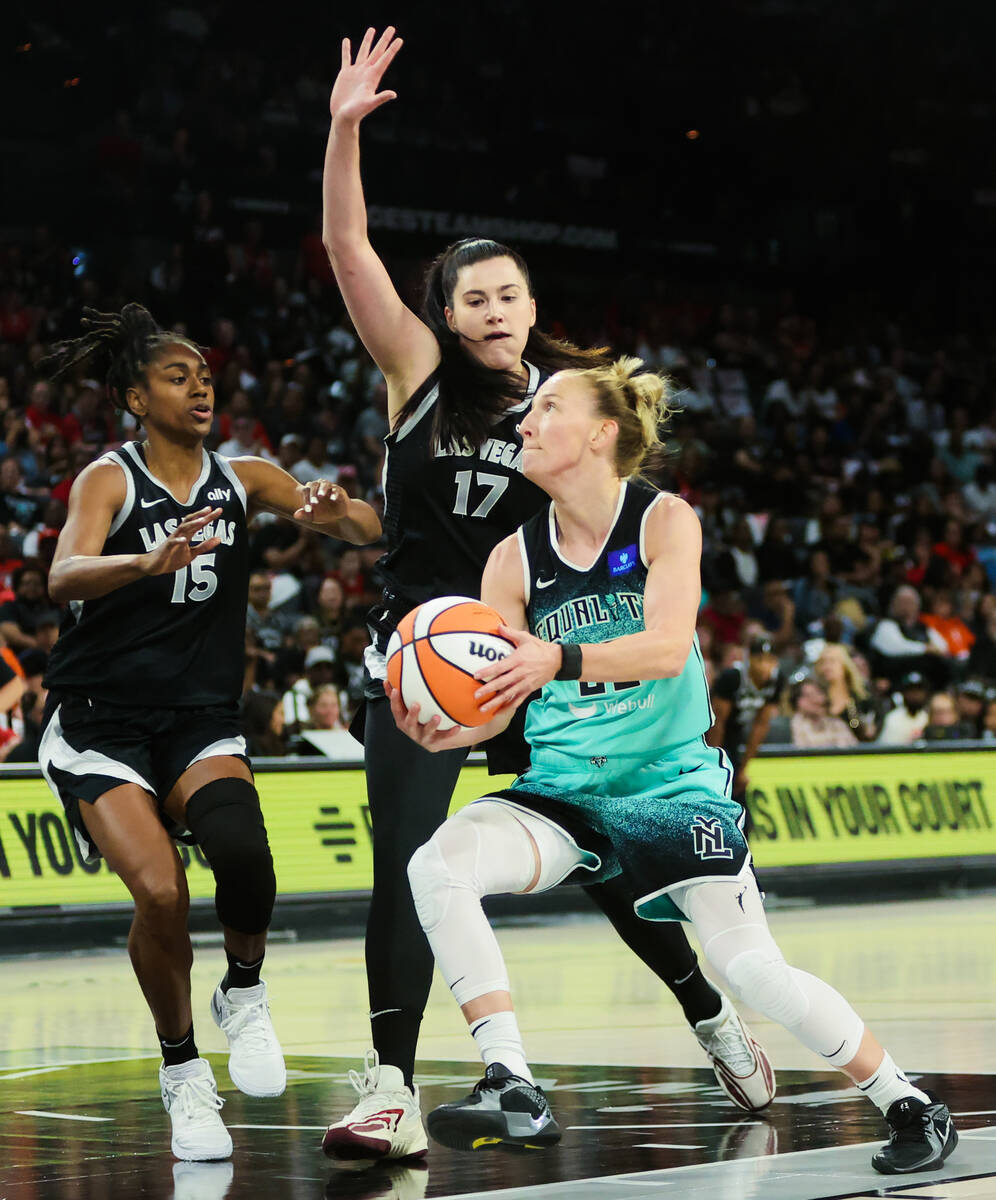 New York Liberty guard Courtney Vandersloot (22) forces her way onto the paint while Aces cente ...