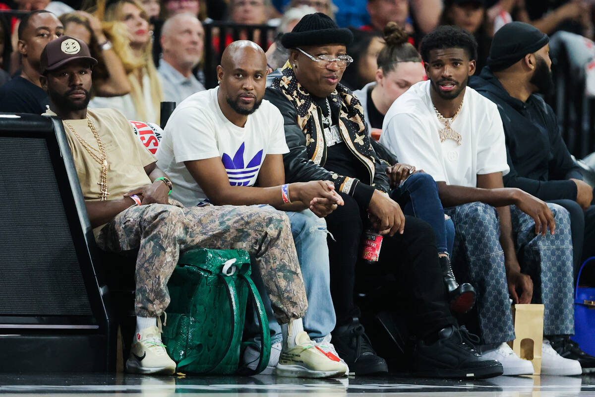 Floyd Mayweather, left, watches game action as rapper E-40, second from right, and Shedeur Sand ...