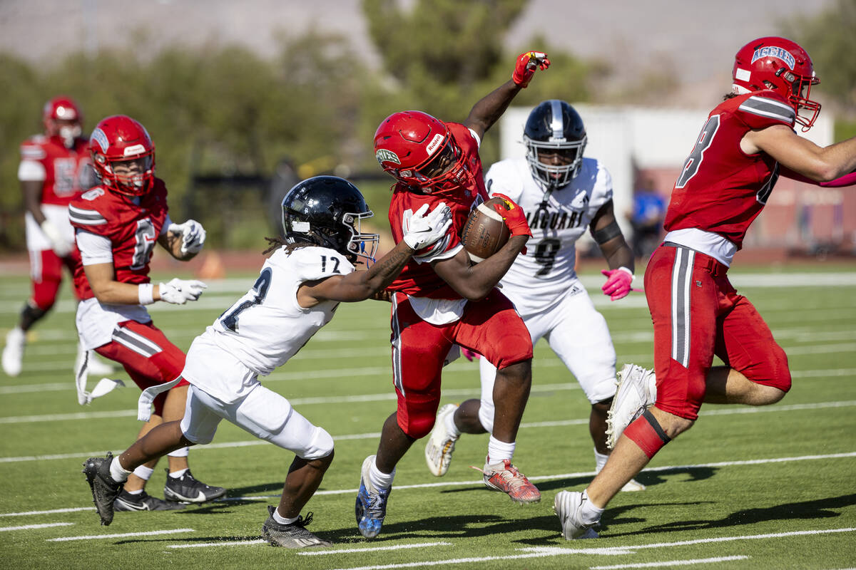 Arbor View running back Kamareion Bell (0) avoids a tackle during the high school football game ...