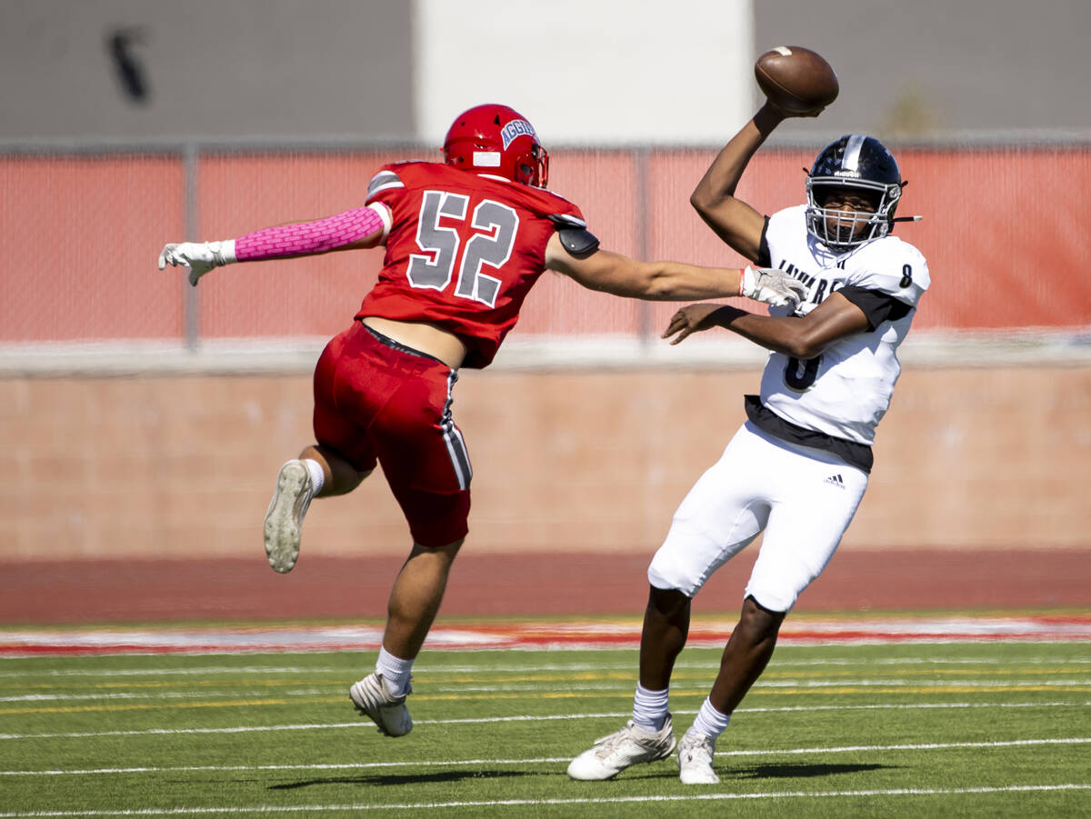 Desert Pines quarterback Zeyshawn Martin (8) avoids Arbor View linebacker Rocky Campbell (52) d ...