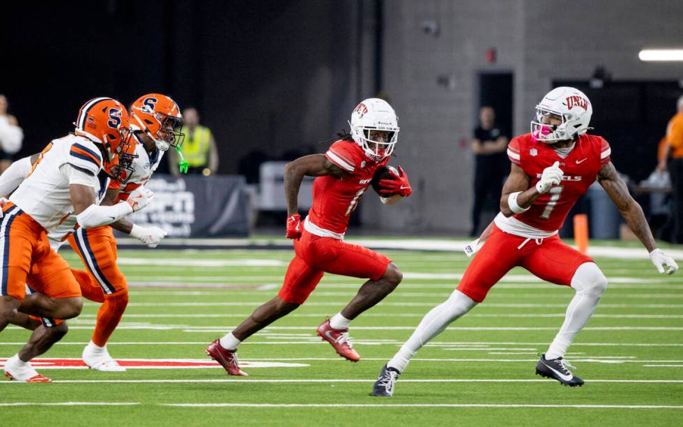 UNLV wide receiver Ricky White III (11) avoids a group of Syracuse Orange defenders during the ...