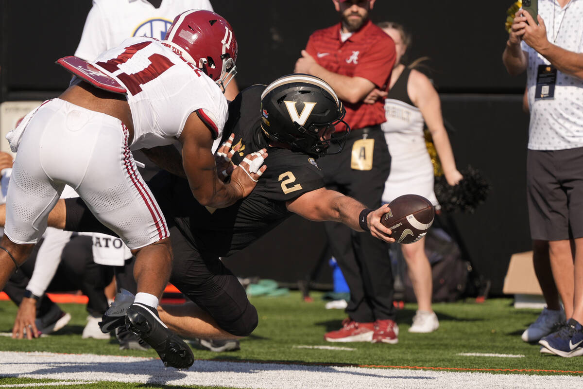 Vanderbilt quarterback Diego Pavia (2) dives for extra yards past Alabama linebacker Jihaad Cam ...