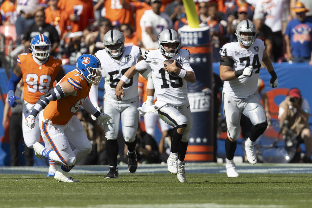 Raiders quarterback Gardner Minshew (15) rushes for a first down with Denver Broncos defensive ...