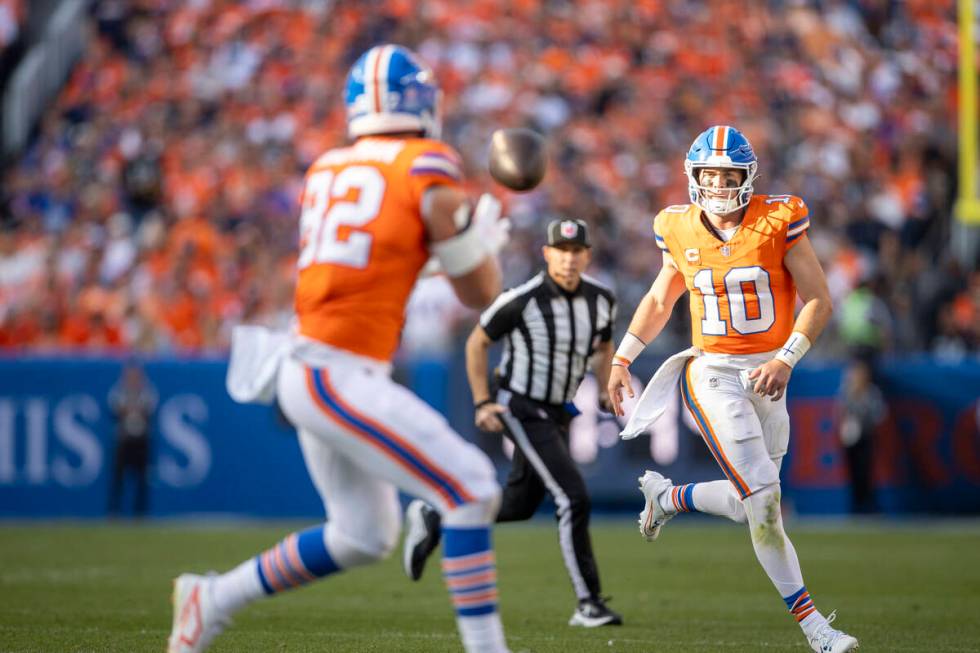 Denver Broncos quarterback Bo Nix (10) passes the football to tight end Adam Trautman (82) duri ...