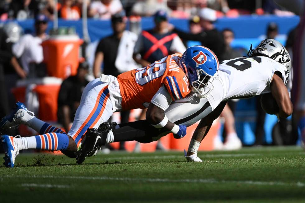 Denver Broncos cornerback Ja'Quan McMillian (29) tackles Las Vegas Raiders wide receiver Jakobi ...