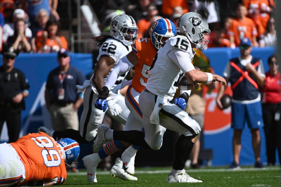 Las Vegas Raiders quarterback Gardner Minshew (15) pulls away from Denver Broncos linebacker Co ...