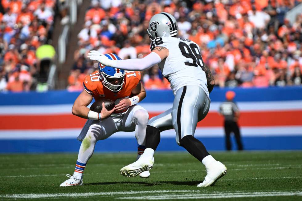 Denver Broncos quarterback Bo Nix (10) is sacked by Las Vegas Raiders defensive end Maxx Crosby ...