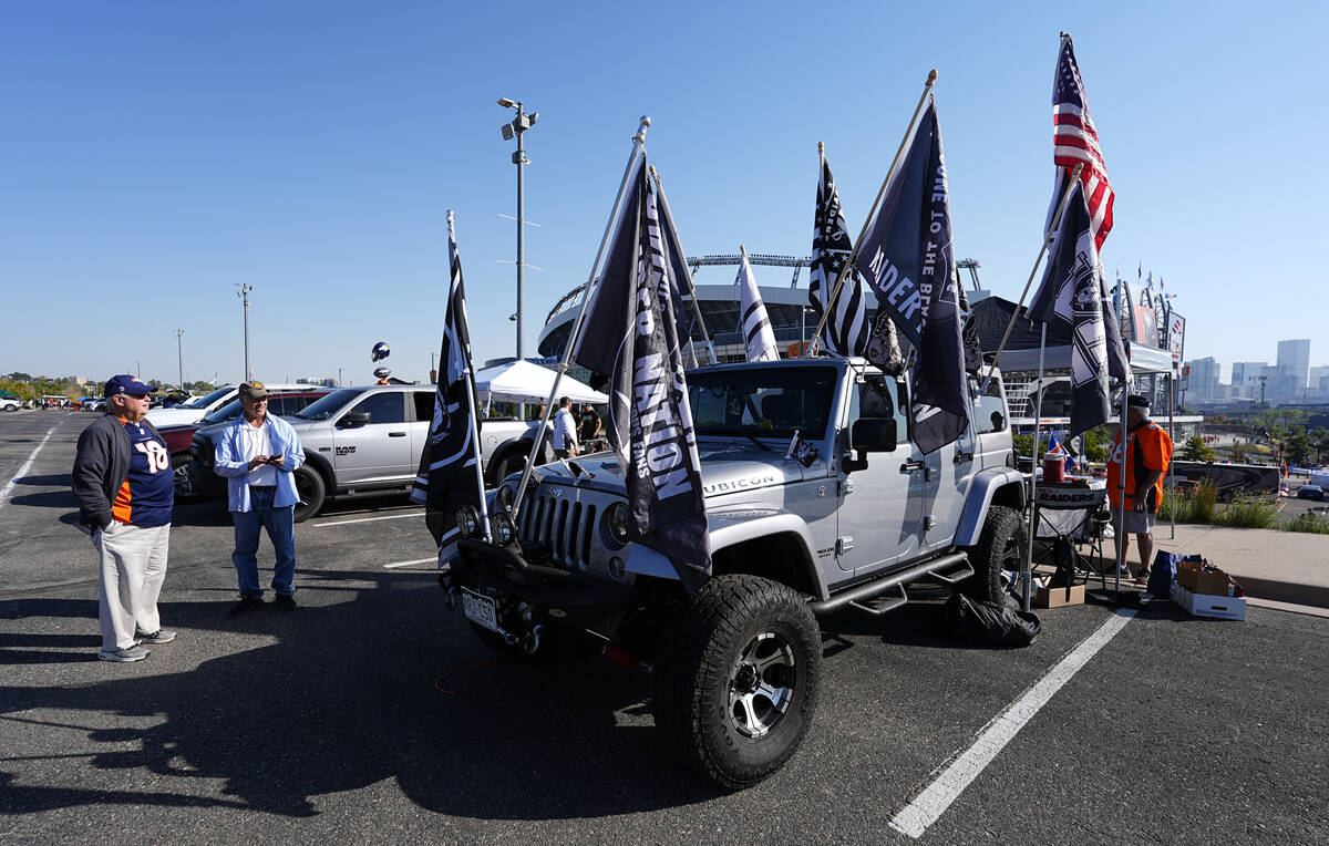 A Las Vegas Raiders fan displays team flags on his Jeep Wrangler before an NFL football game ag ...