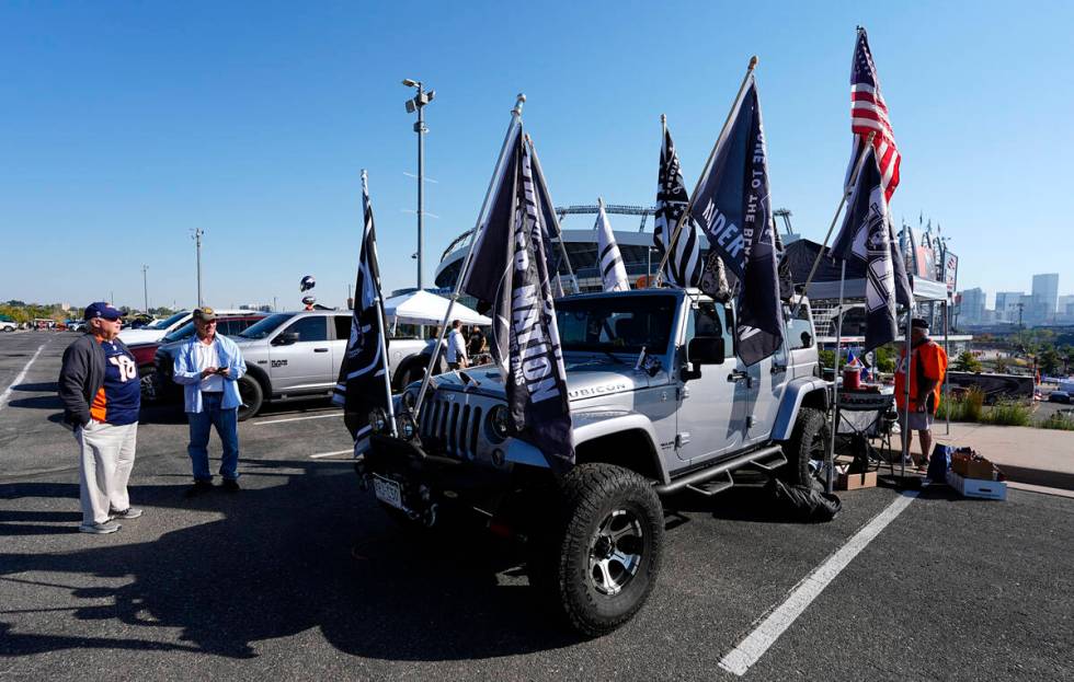 A Las Vegas Raiders fan displays team flags on his Jeep Wrangler before an NFL football game ag ...