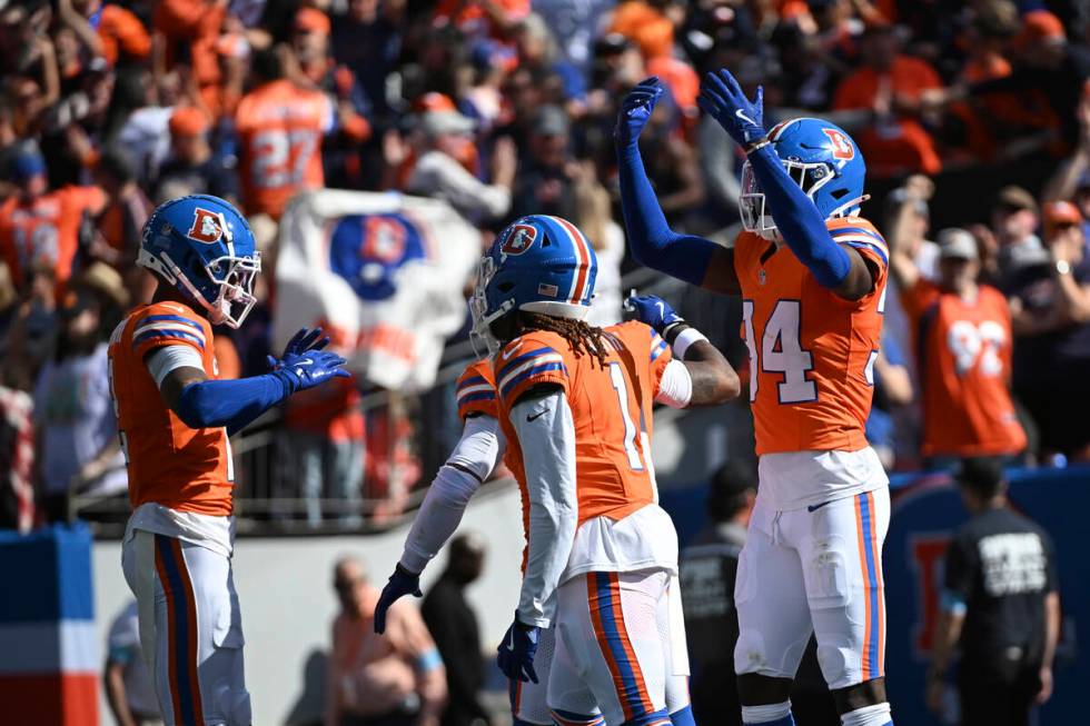 Denver Broncos cornerback Pat Surtain II, left, celebrates his 100-yard interception for a touc ...