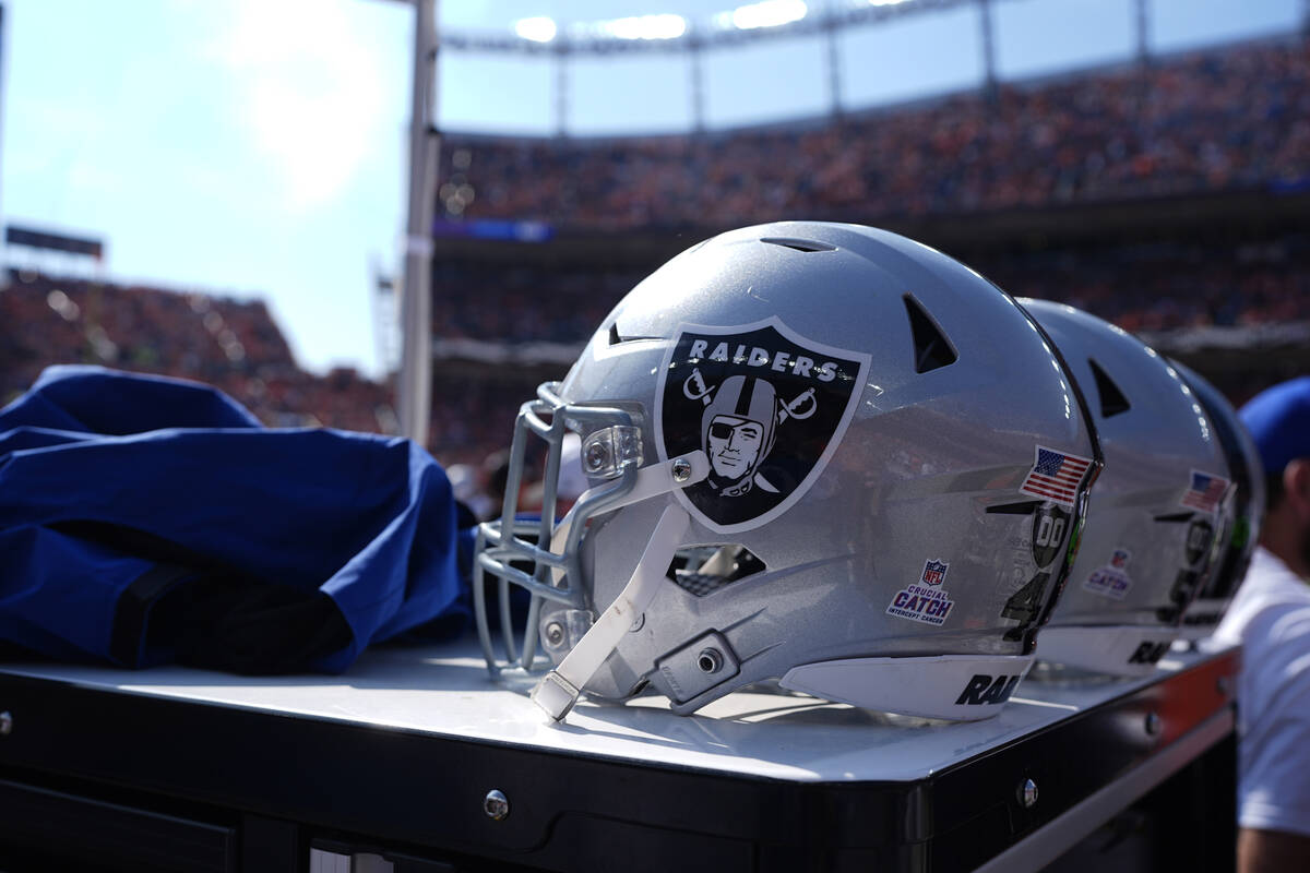 Las Vegas Raiders helmets are lined up in the bench area during the first half of an NFL footba ...