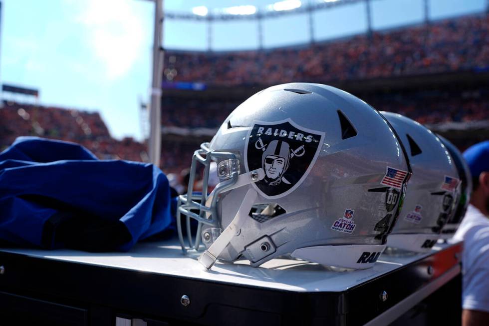 Las Vegas Raiders helmets are lined up in the bench area during the first half of an NFL footba ...