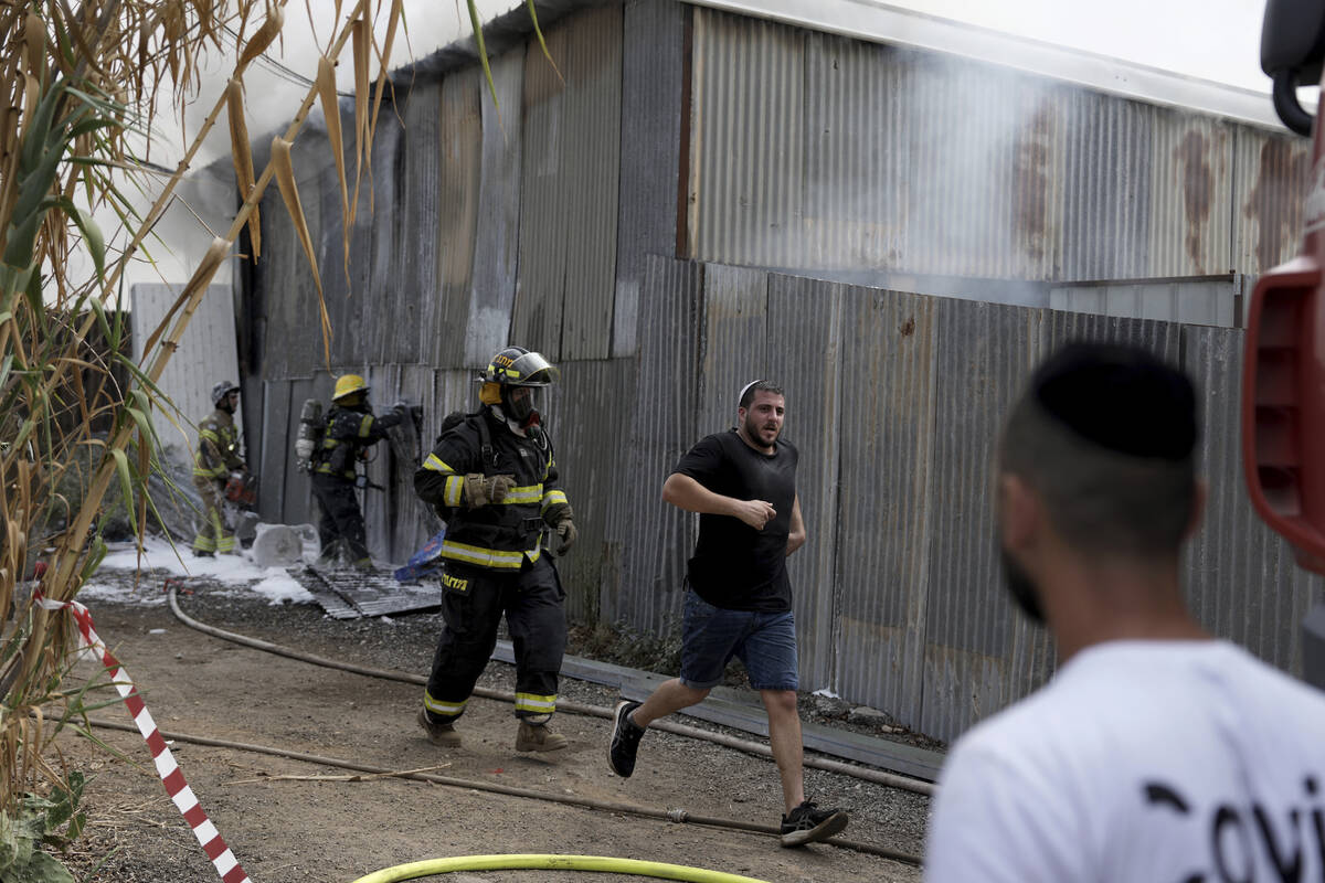 Residents run away as emergency personnel respond after a rocket apparently fired from Gaza hit ...