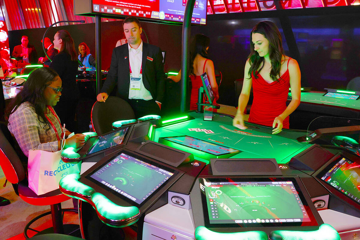 A conventioneer plays on Interblock Gaming's Smart Pit 5-seaters Blackjack table at G2E Las Veg ...