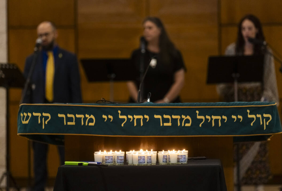 Singers perform as candles burn during a ceremony at Midbar Kodesh Temple marking one year sinc ...