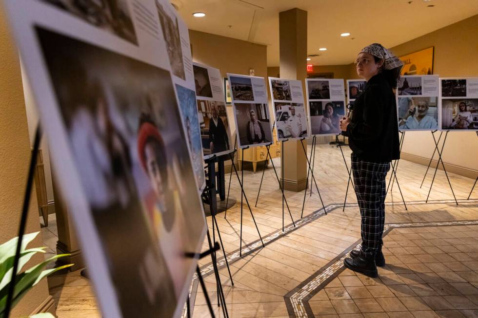 Attendees look through photos of hostages before a ceremony at Midbar Kodesh Temple marking one ...