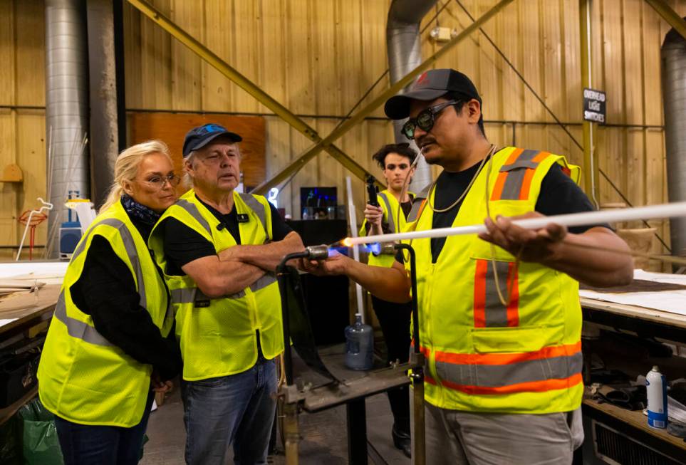 Todd Fisher, second from left, and wife Catherine Hickland get a demonstration from YESCO neon ...