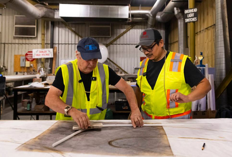 Todd Fisher, left, bends a neon tube with guidance from YESCO neon bender Oscar Gonzalez on Wed ...