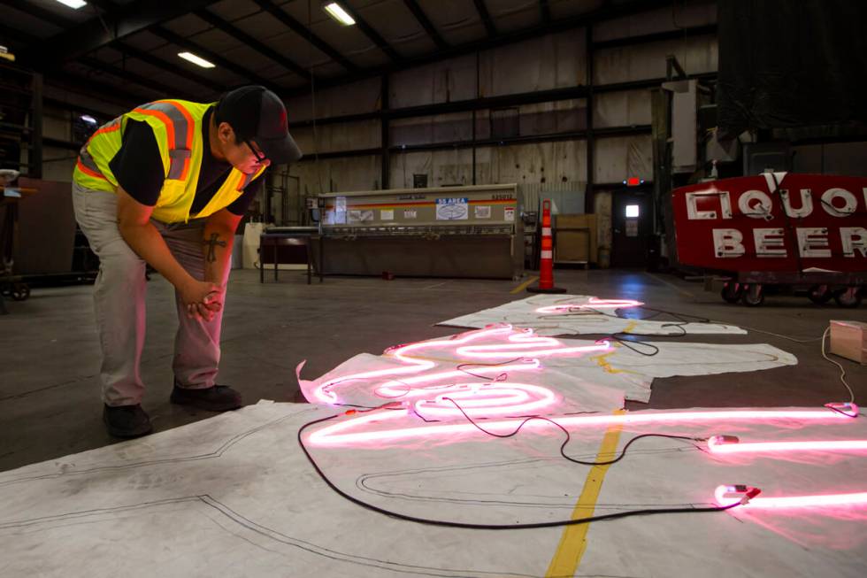 YESCO neon bender Oscar Gonzalez works on placing neon tubes on a diagram for the renovation of ...