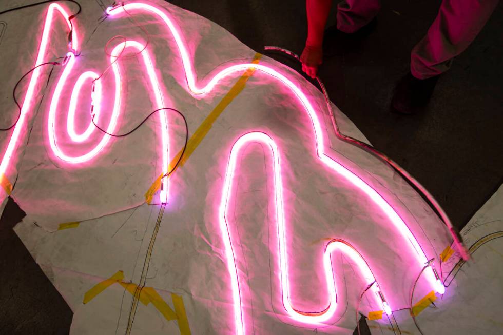 YESCO neon bender Oscar Gonzalez holds one of the old neon tubes, right, next to the newly crea ...