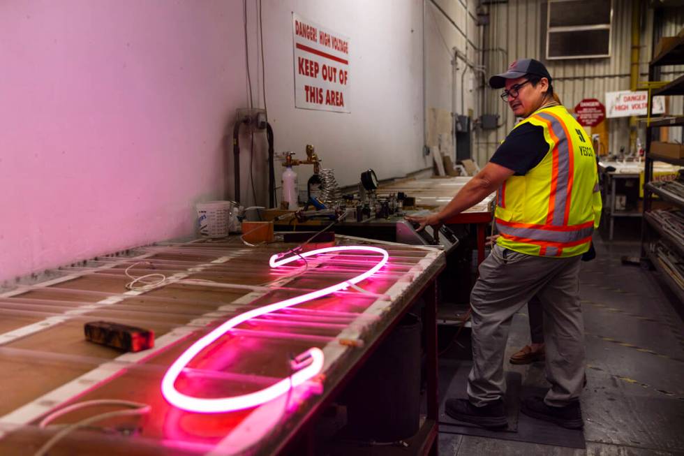 YESCO neon bender Oscar Gonzalez lights up a neon tube while working on the renovation of the & ...