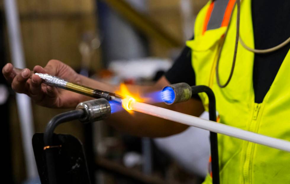 YESCO neon bender Oscar Gonzalez blows glass for a neon tube on Sept. 4 in Las Vegas. (Chase St ...